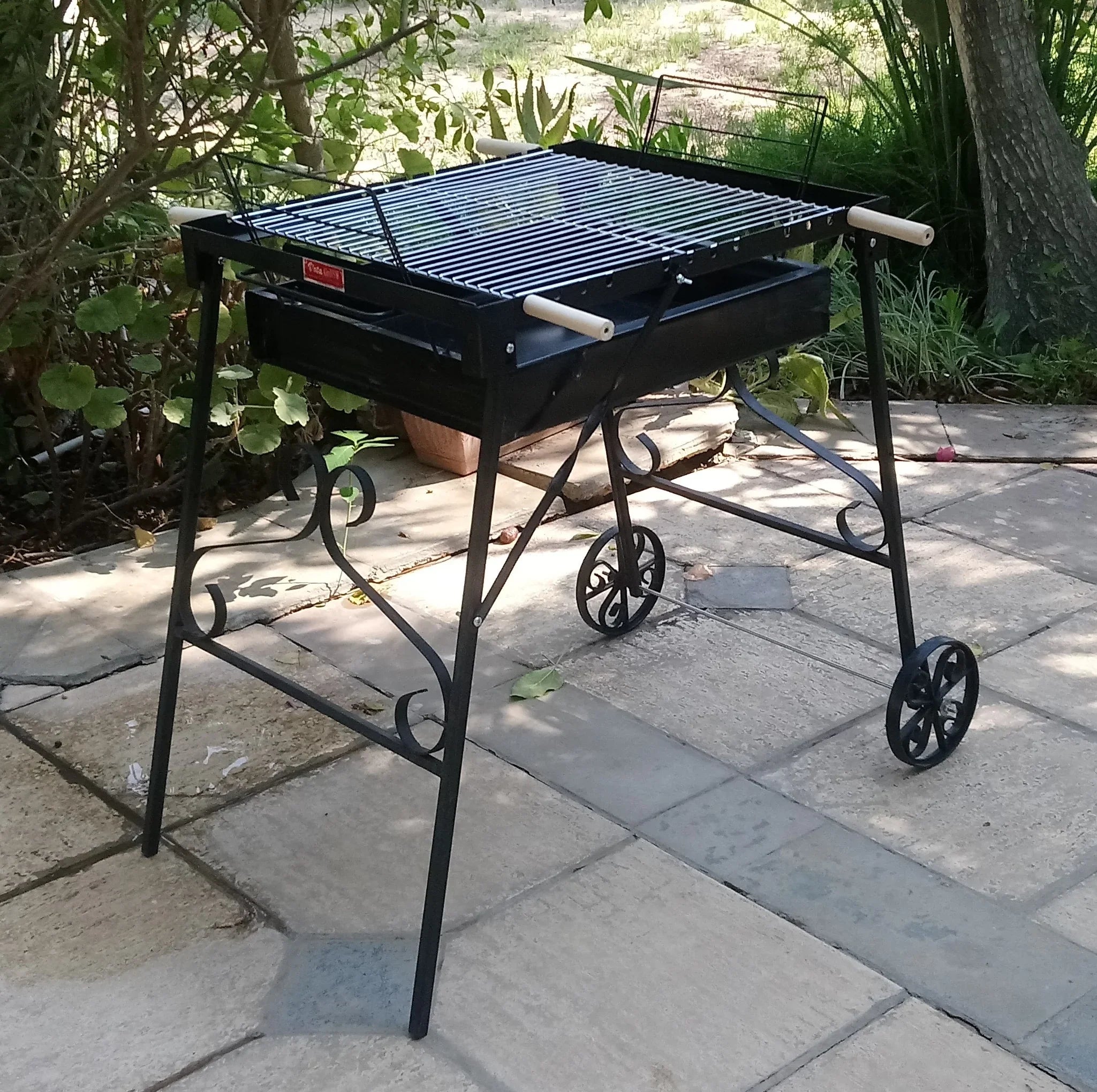 Portable grill on wheels outdoors on a stone patio vota garden grill شوايه فوتا للحديقه فحم